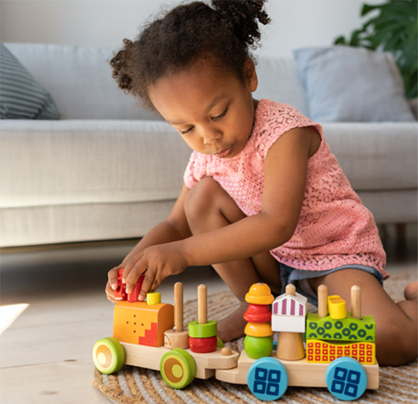 Young girl playing with a wooden train