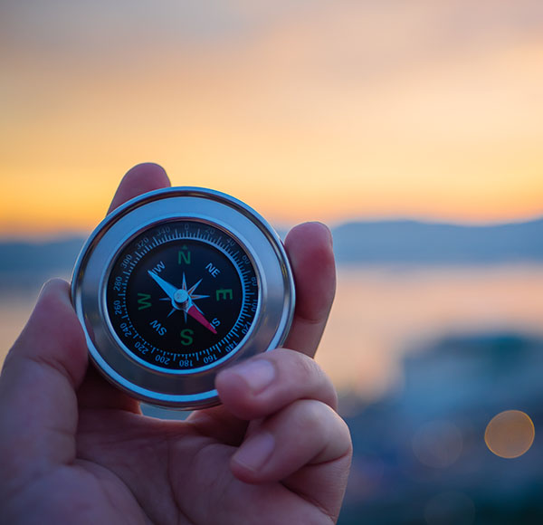 A hand holding a compass