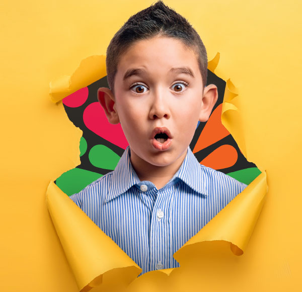 Surprised boy looking through a hole in a paper wall