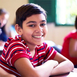 A smiling young person at a school desk
