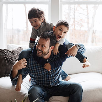 Two boys climb on their father's back