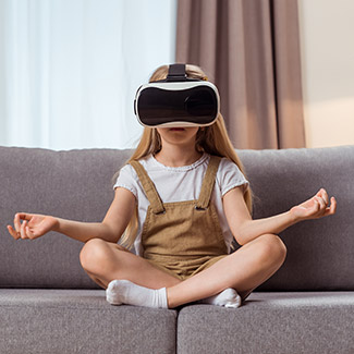 Girl meditating on a couch while wearing a virtual reality headset