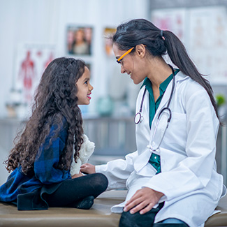 A doctor chats with a young girl