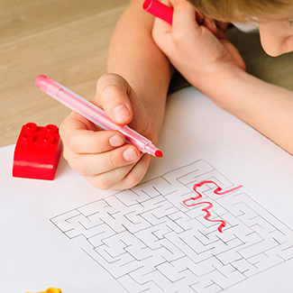 Boy with a marker solving a maze