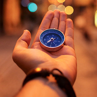 A hand holding a compass