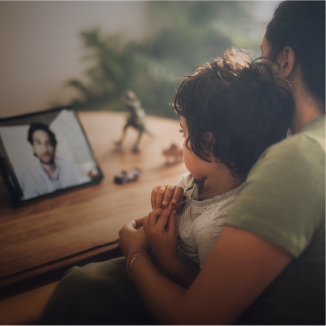 A parent and child talk to a doctor on a tablet