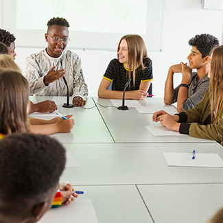 Youth talking at a boardroom table