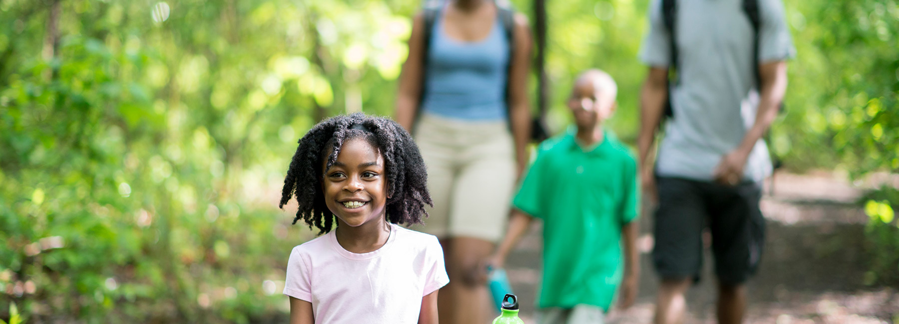 A family walking on a forest path