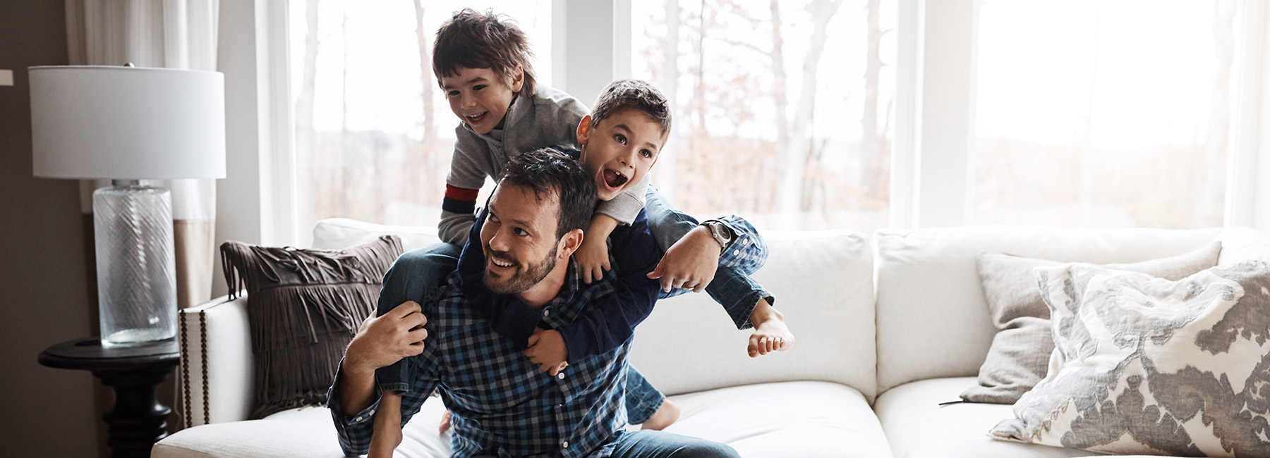 Two boys climb on their father's back