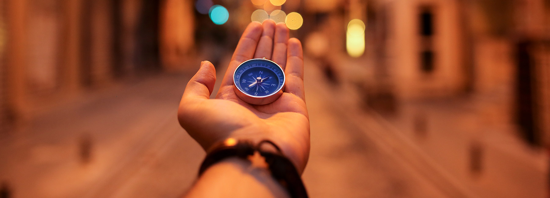 A hand holding a compass