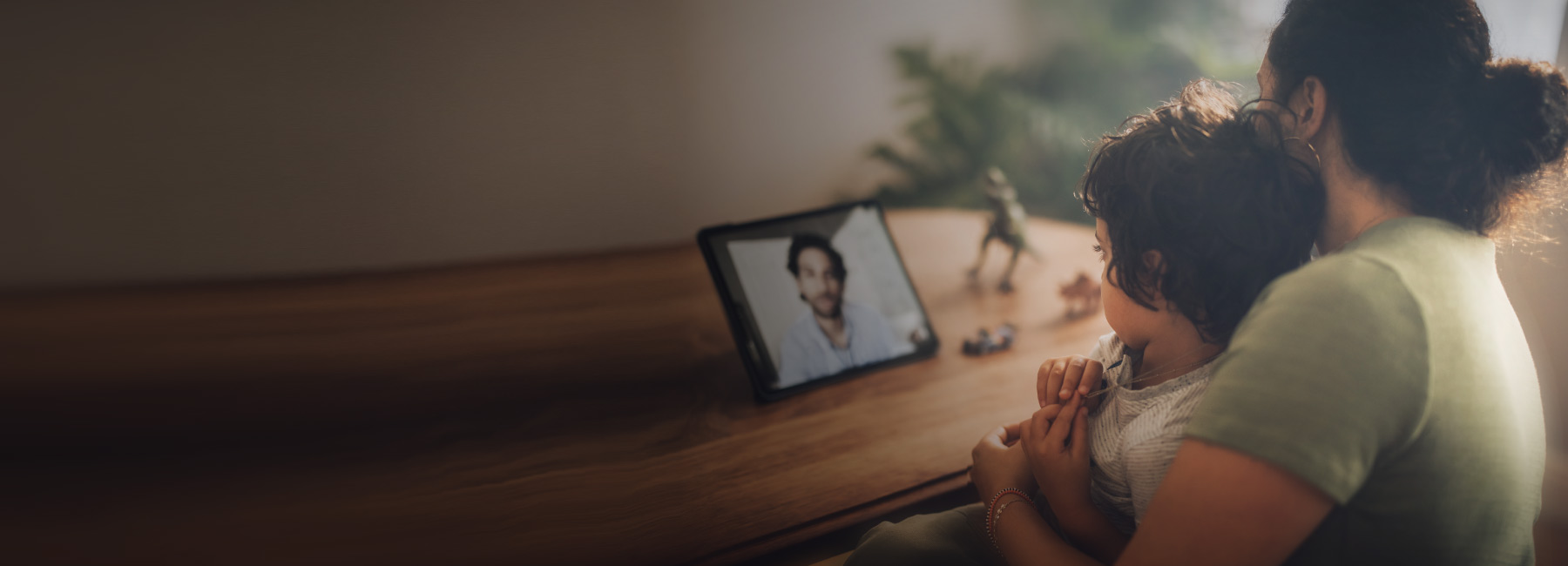 A parent and child talk to a doctor on a tablet