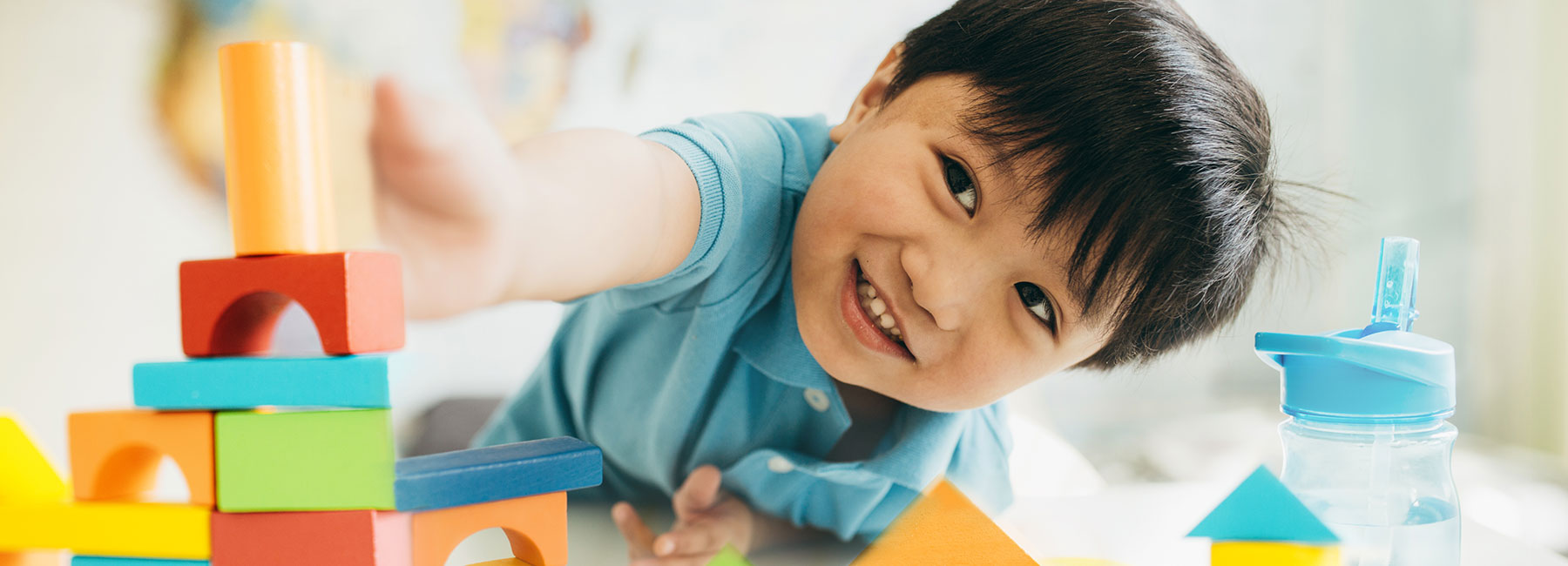 A boy builds a tower of blocks